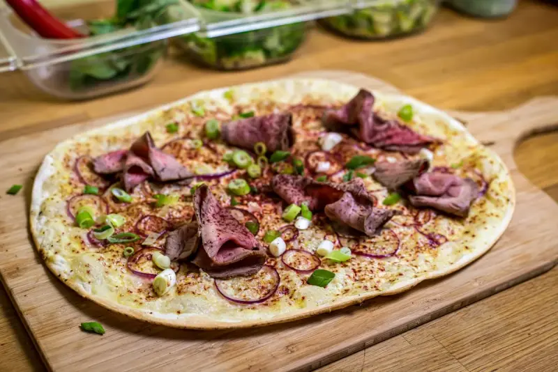 Flammekueche dorée sur planche en bois